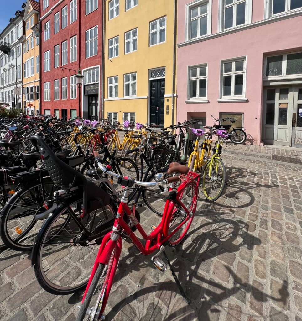 Bicycles parked on the street in Nyhavn, Copenhagen in front of colorful houses.
